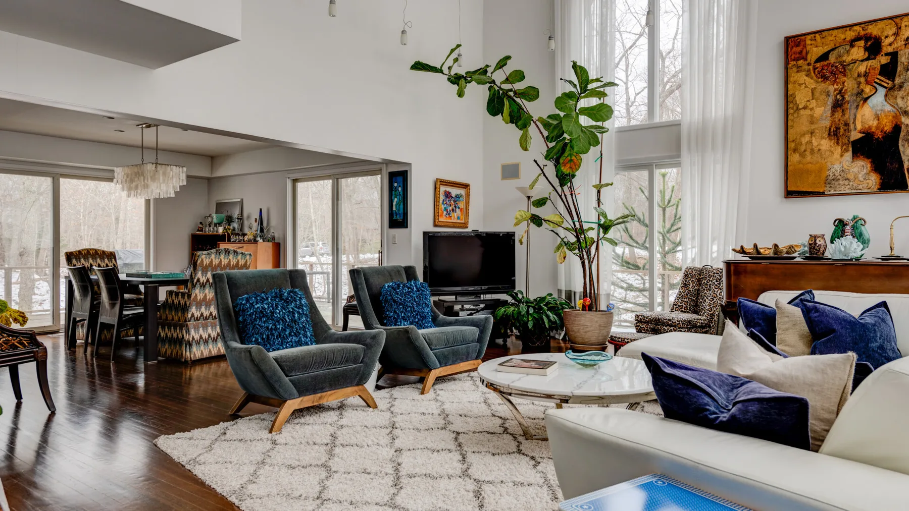 A bright living room with seating arranged around a coffee table and television.
