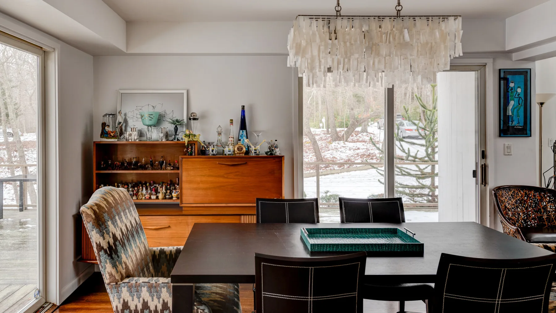 A dining area with a dark table and a wooden display cabinet.