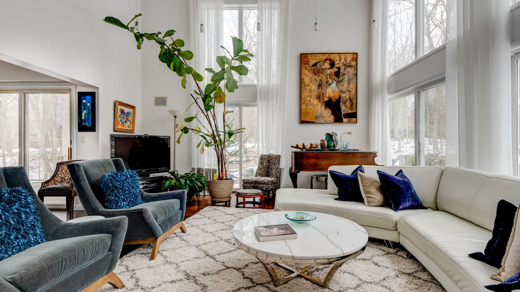 A bright living room with seating arranged around a round coffee table.