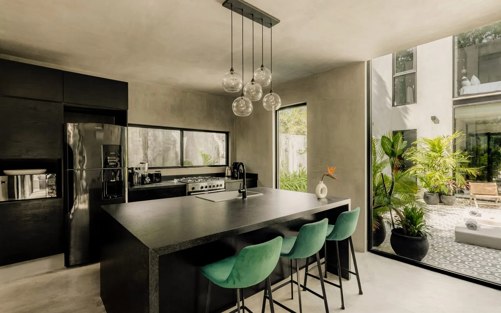 A modern kitchen with a large island and green bar stools.