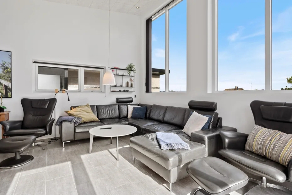 A bright living room with seating arranged around a low white coffee table.