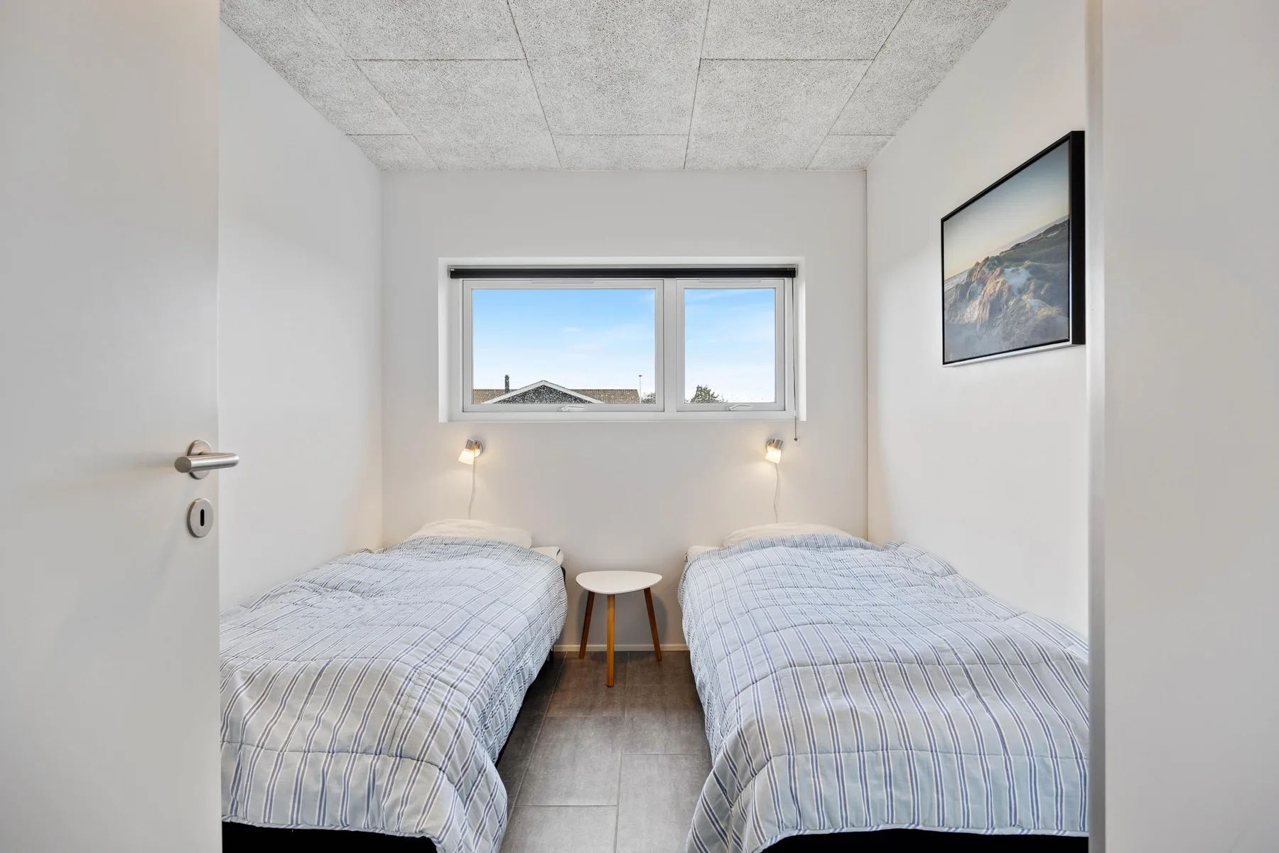Un dormitorio con dos camas individuales y una mesita entre ellas.
