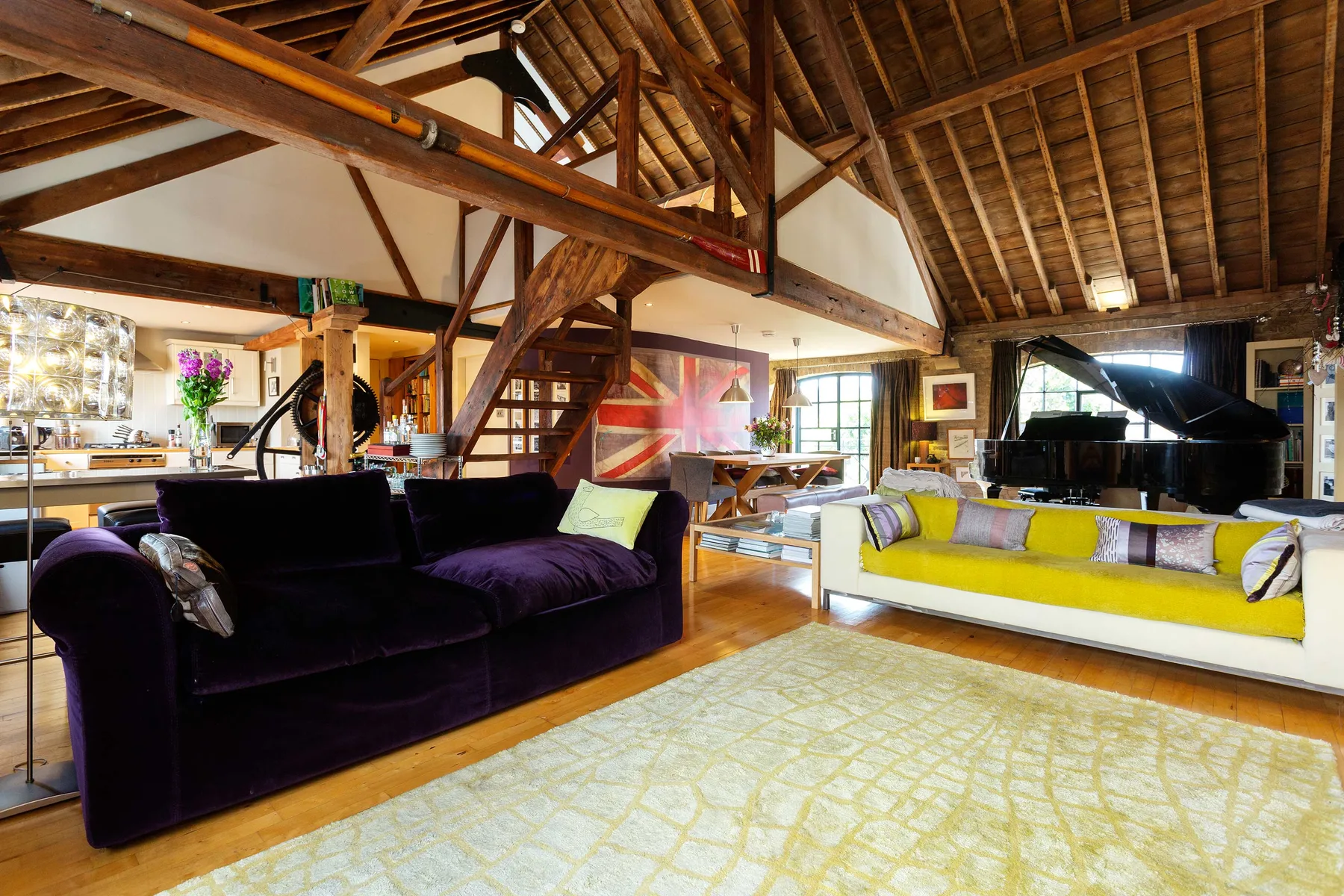 A living room with seating beneath an exposed timber ceiling.