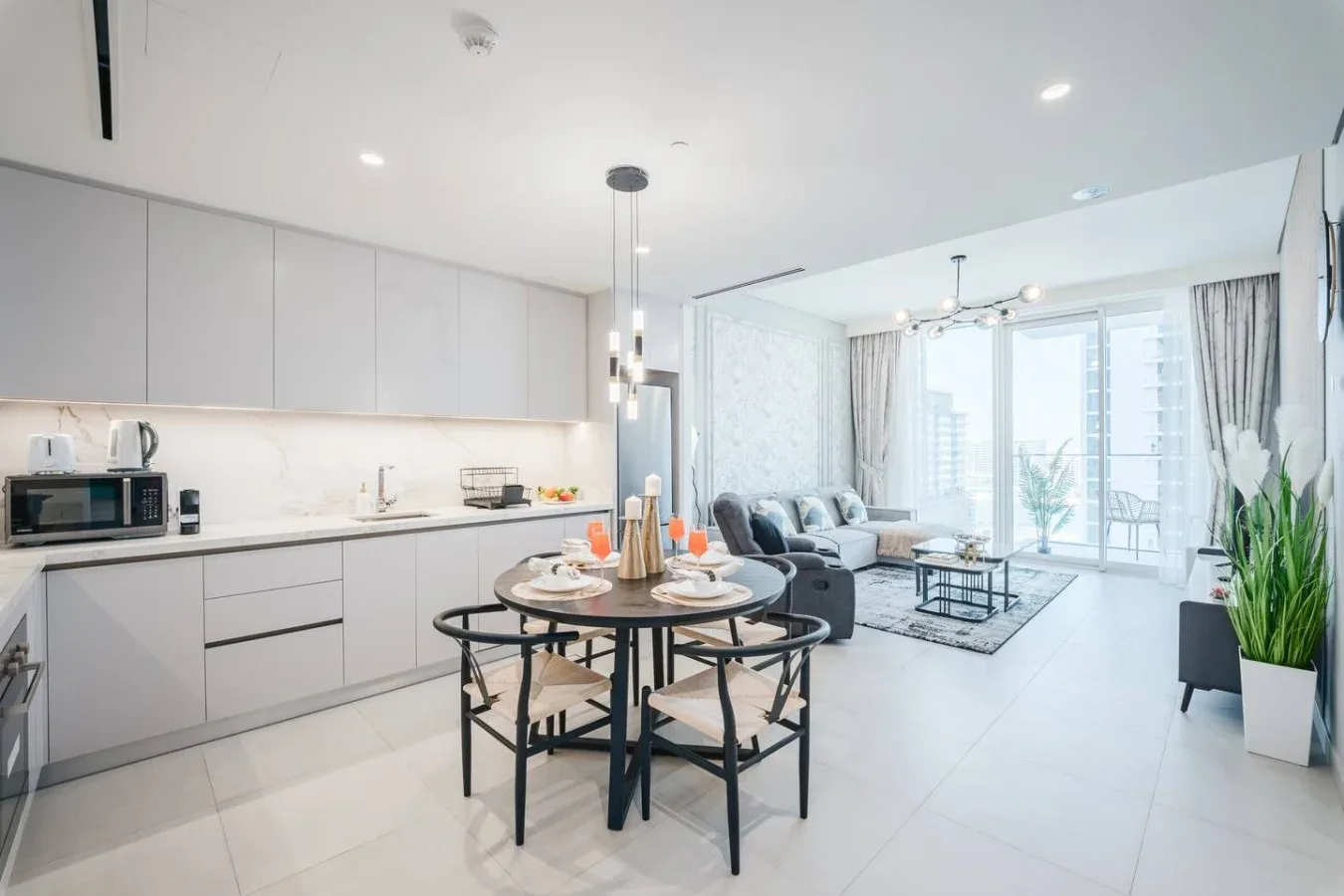 Cocina y comedor de planta abierta con una mesa redonda junto a la sala de estar.