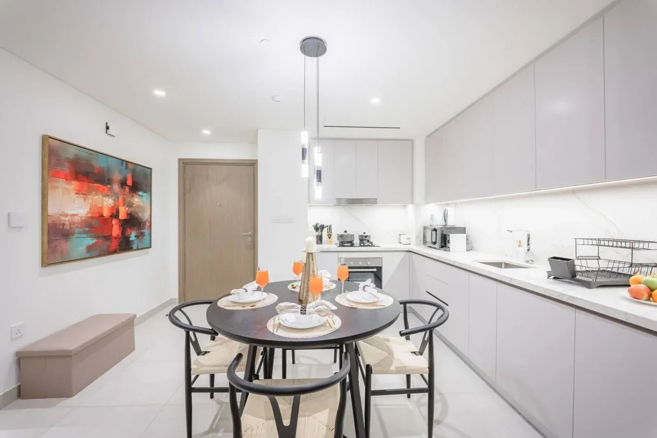 Un comedor luminoso con una mesa redonda junto a una cocina moderna.