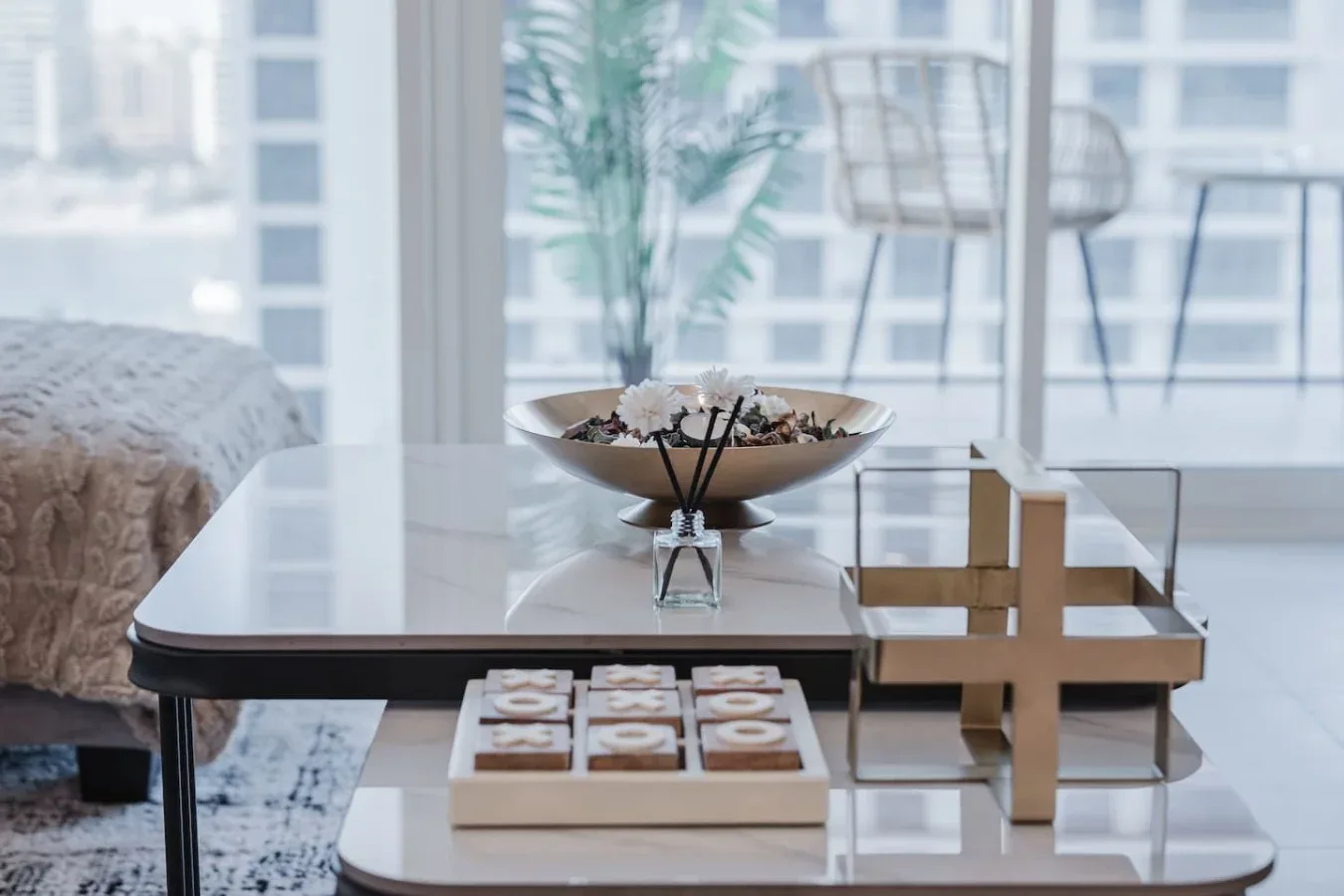 Un comedor luminoso con una mesa, un cuenco decorativo y sillas junto a grandes ventanas.