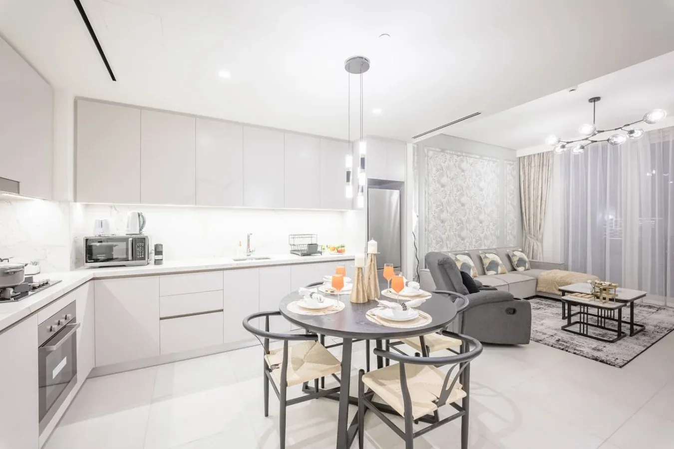 Una luminosa cocina abierta al salón, con mesa de comedor y asientos.