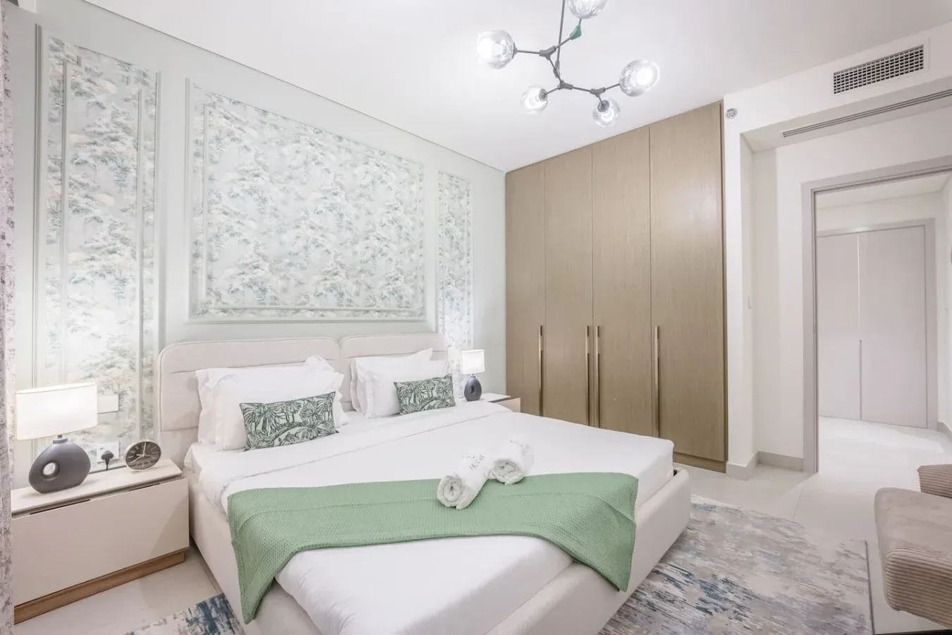 Un dormitorio luminoso con una cama bien tendida y armarios empotrados.