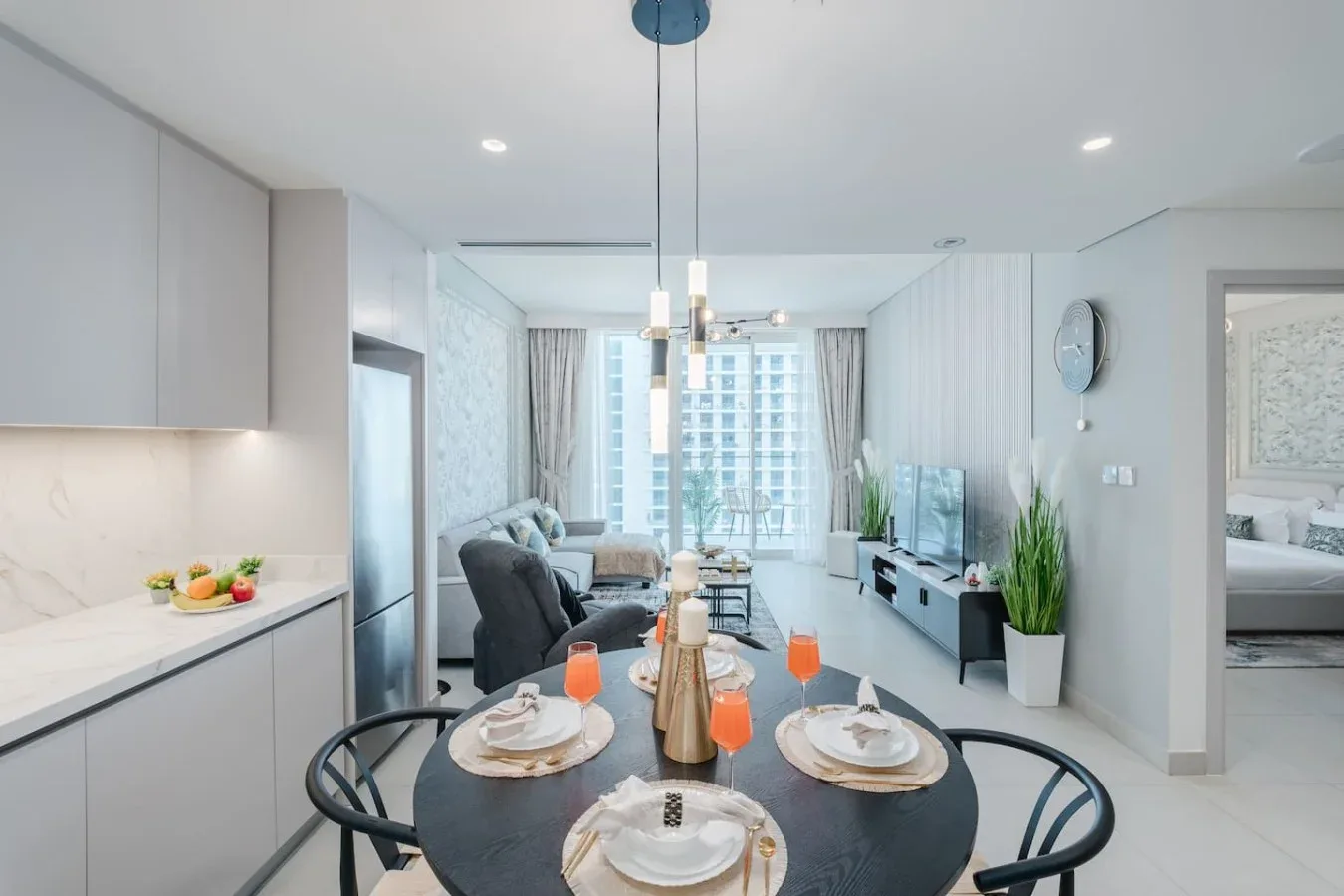 Una luminosa sala de estar y comedor de concepto abierto, con una mesa puesta junto a la cocina.