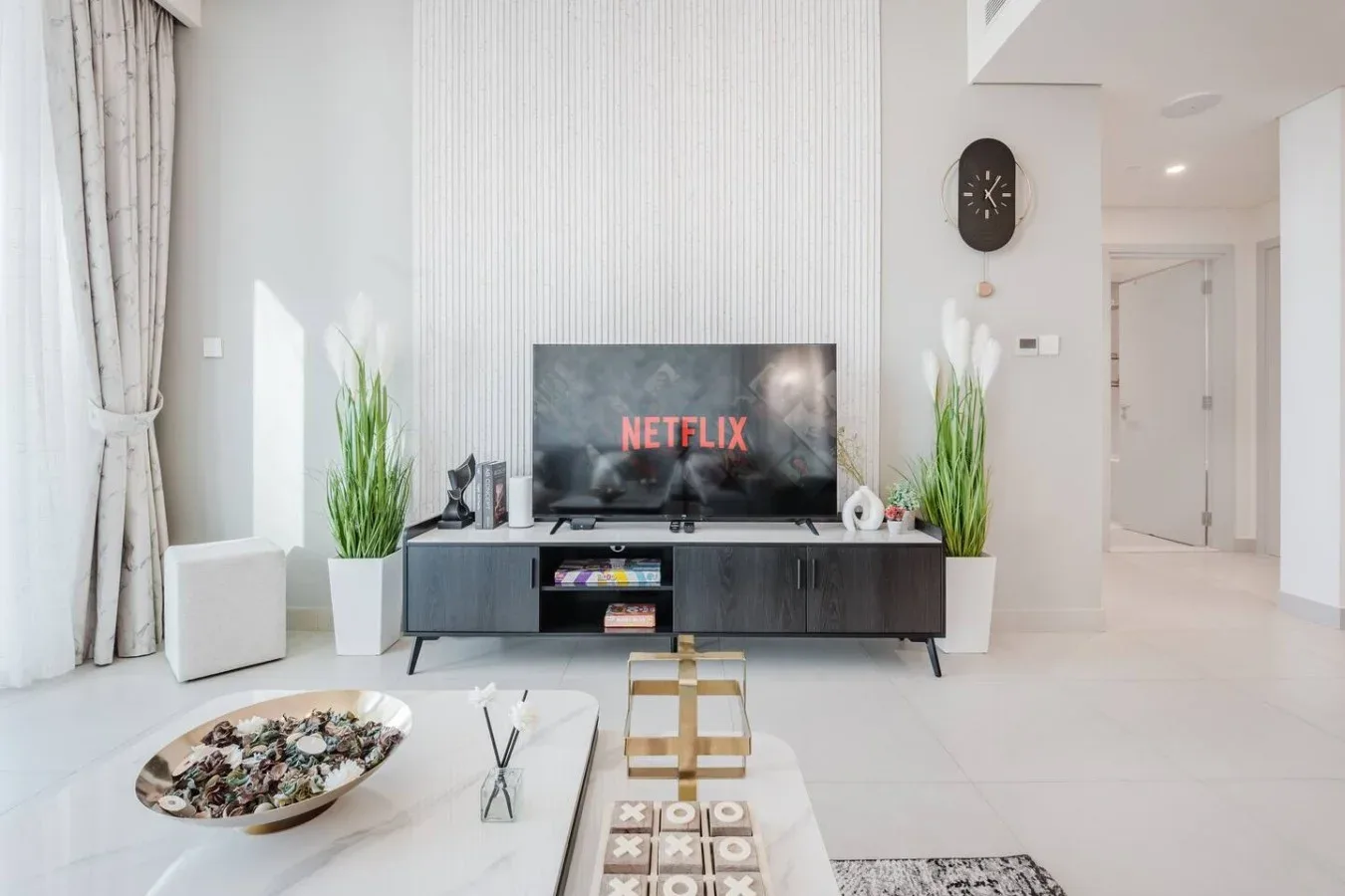Una sala luminosa con un televisor sobre un mueble bajo.