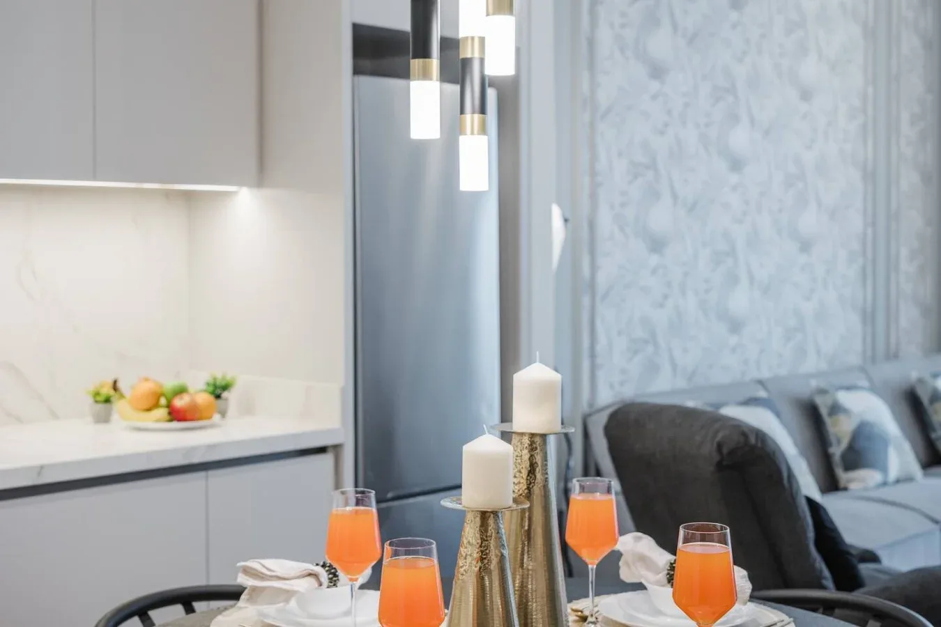Una mesa con bebidas naranjas está junto a una sala de estar con asientos.