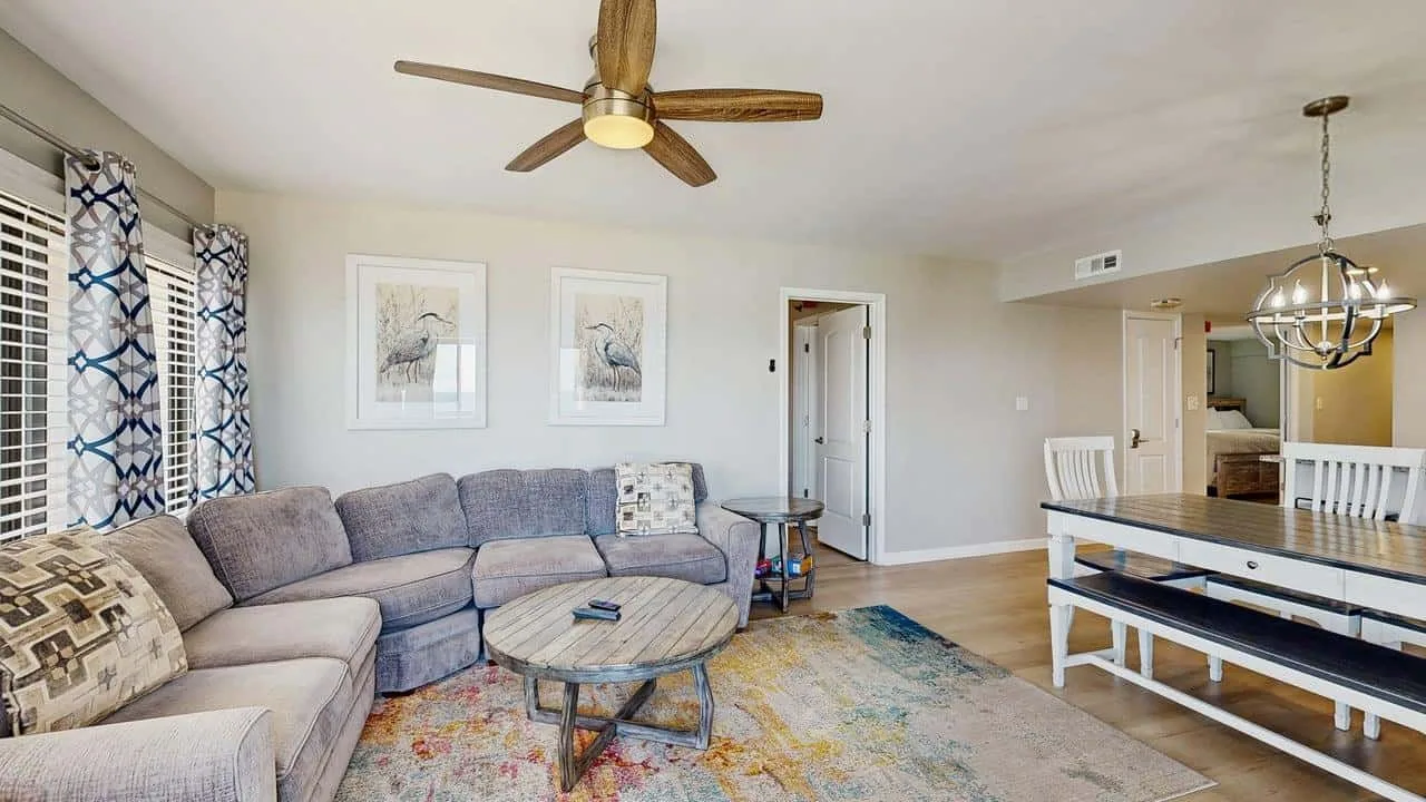 A living room with sectional seating and a dining area.