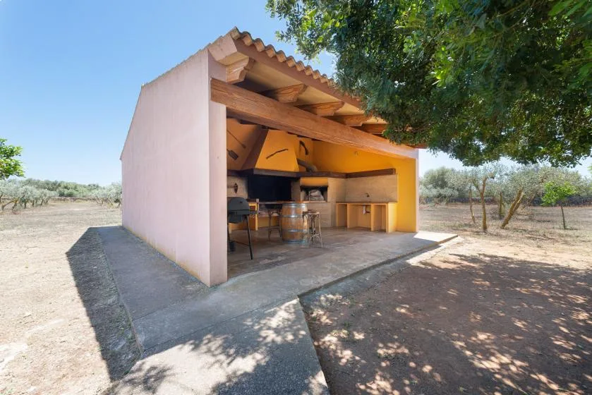Una zona de cocina exterior cubierta con una encimera y asientos.