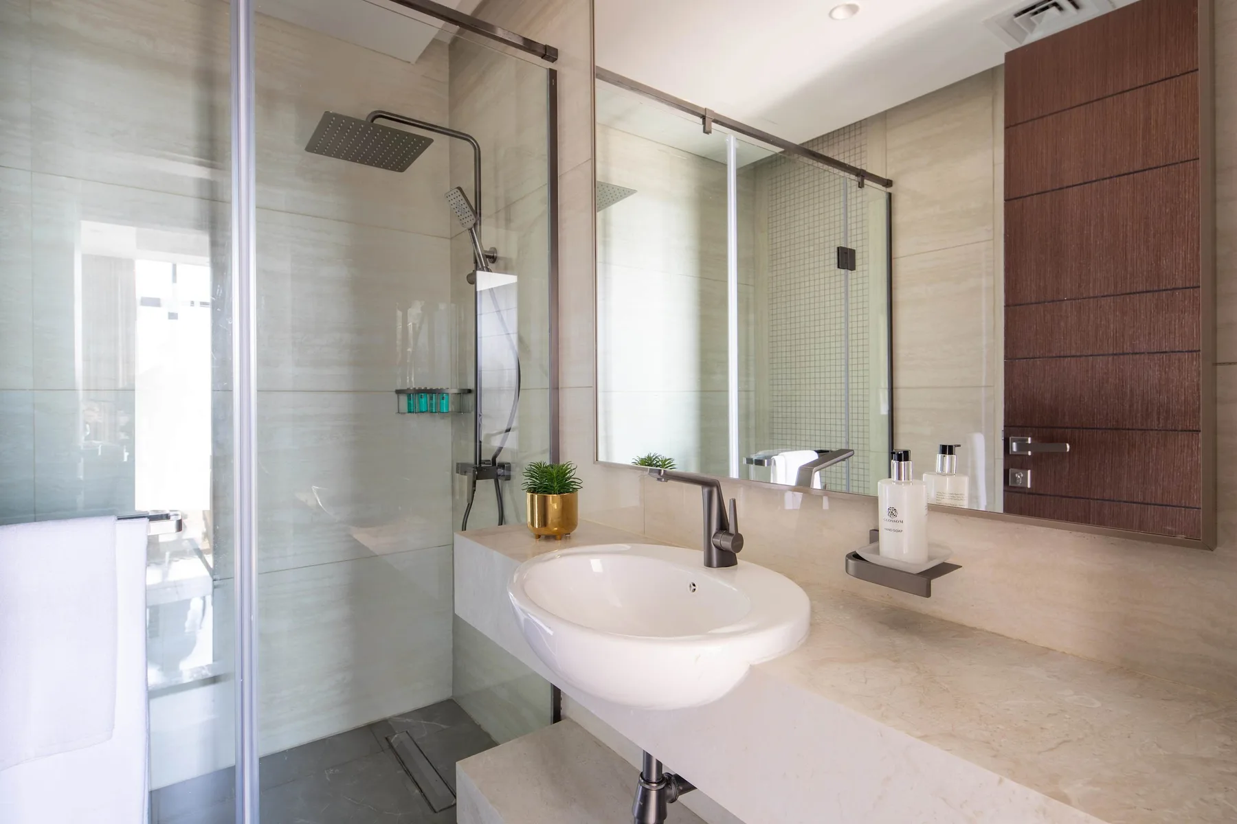 A modern bathroom with a glass shower and a sink beneath a large mirror.