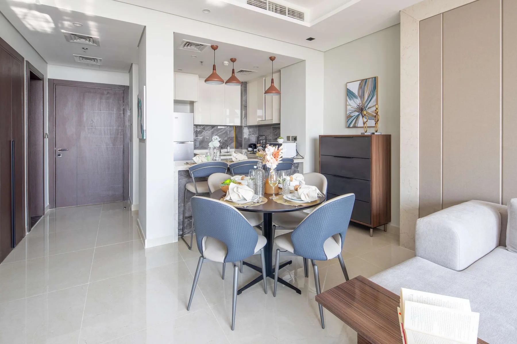 A dining area with blue seating and a table beside the kitchen.