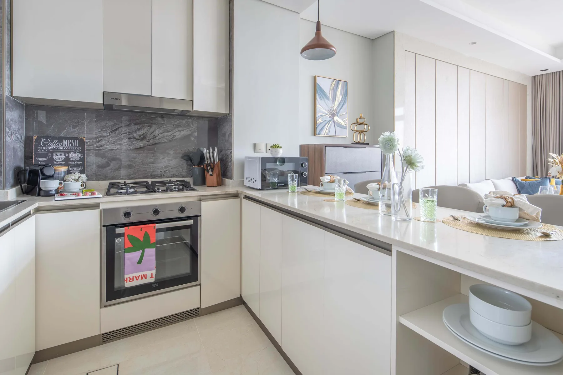 A bright open-plan kitchen and dining area with a long island and adjoining seating.