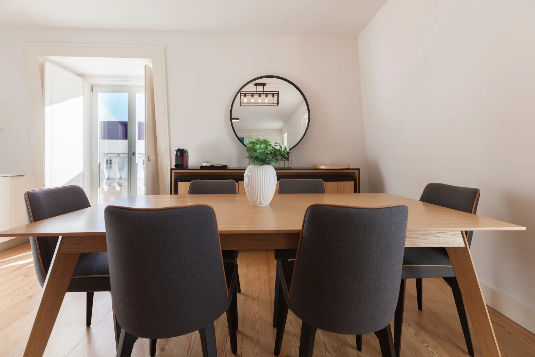 A dining area with a wooden table and dark upholstered seating.