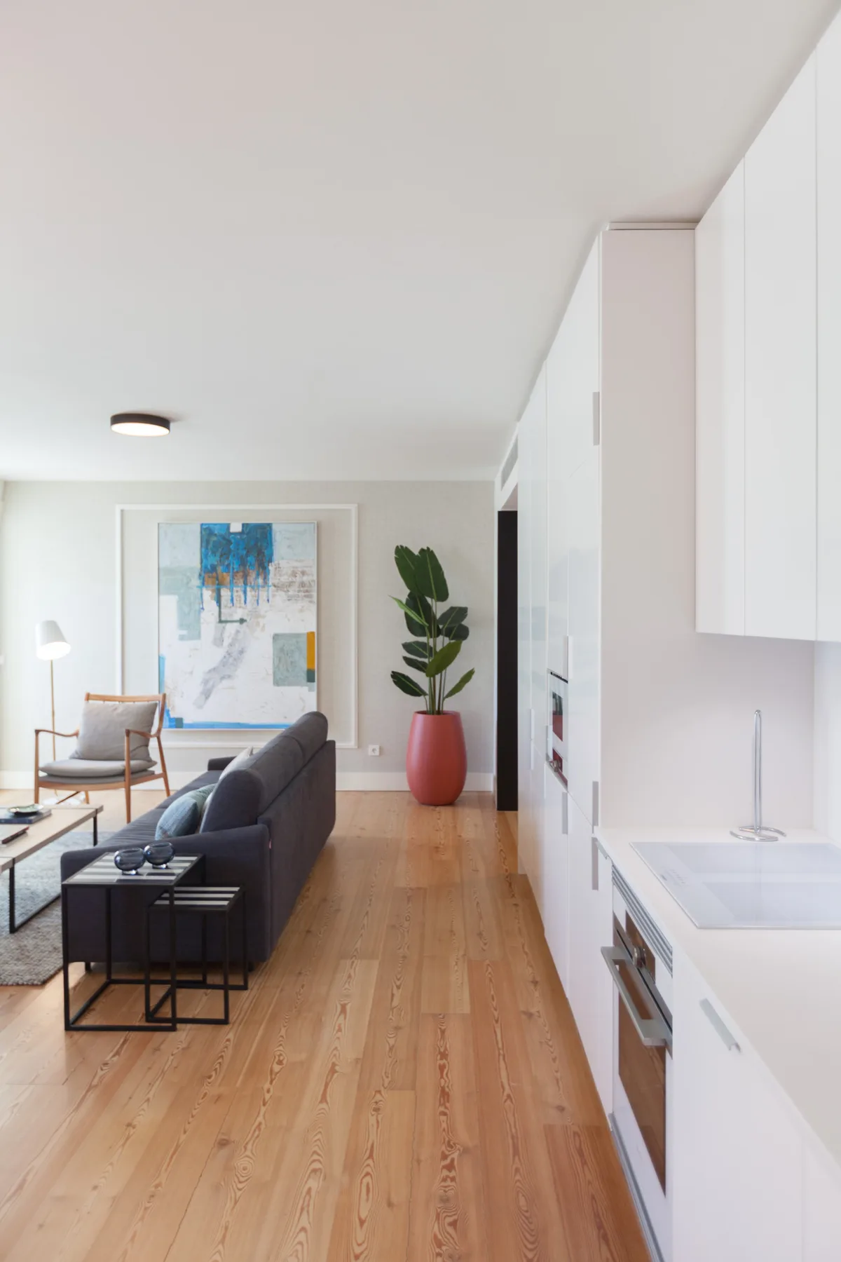 A bright open-plan living room and kitchen with wood flooring and contemporary furnishings.