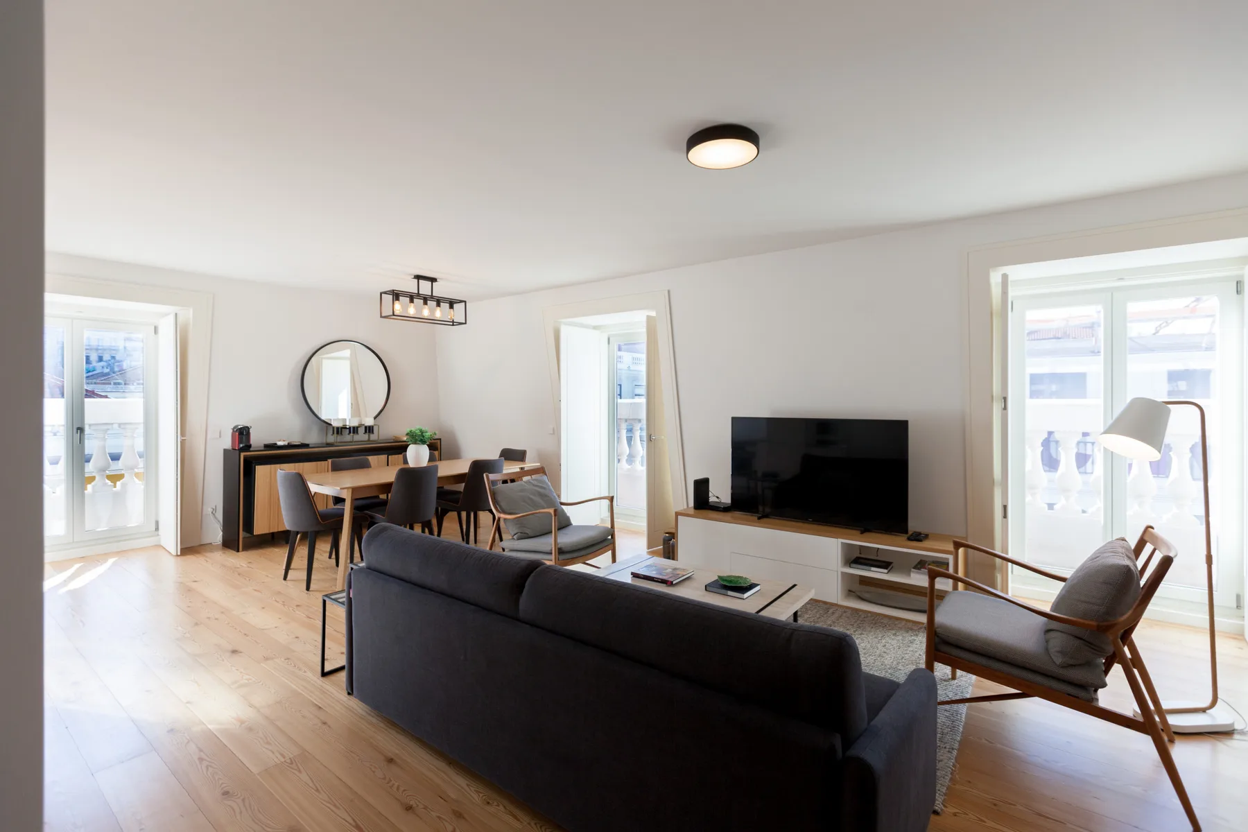 Una sala luminosa con asientos, un televisor y una mesa de comedor.