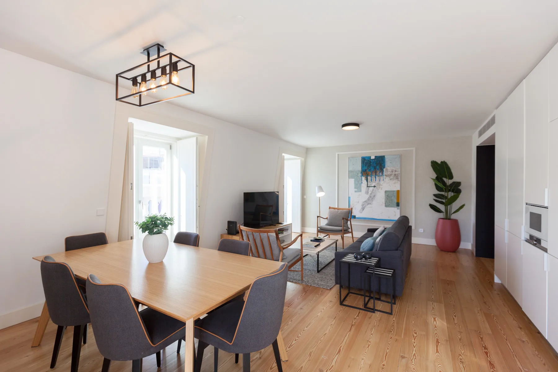 A bright apartment living and dining area with a dining table and seating.