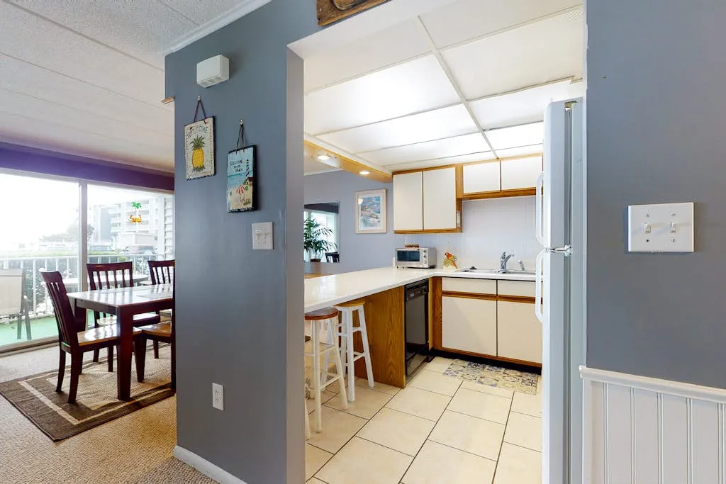 An open kitchen and dining area with a counter and table by the windows.