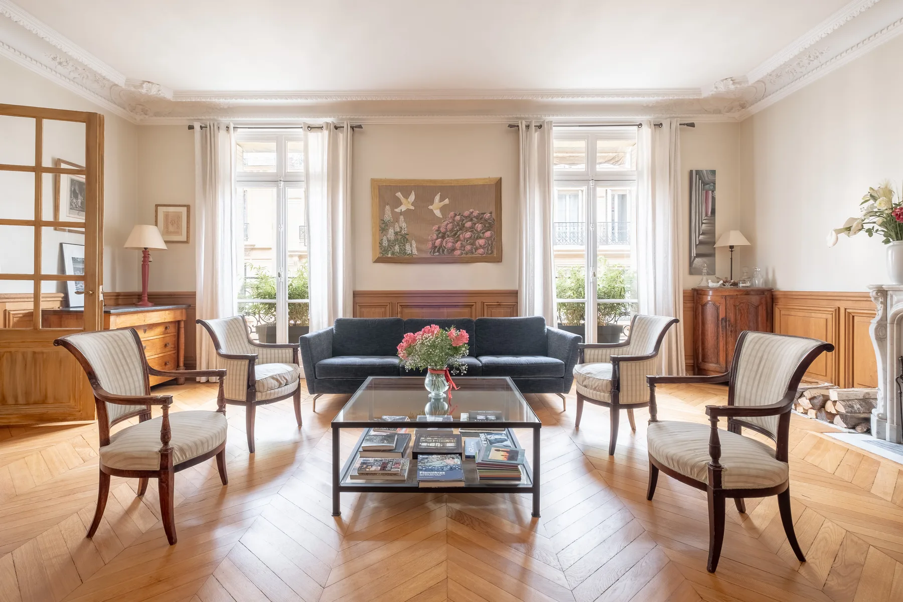 A bright living room with seating arranged around a glass coffee table.