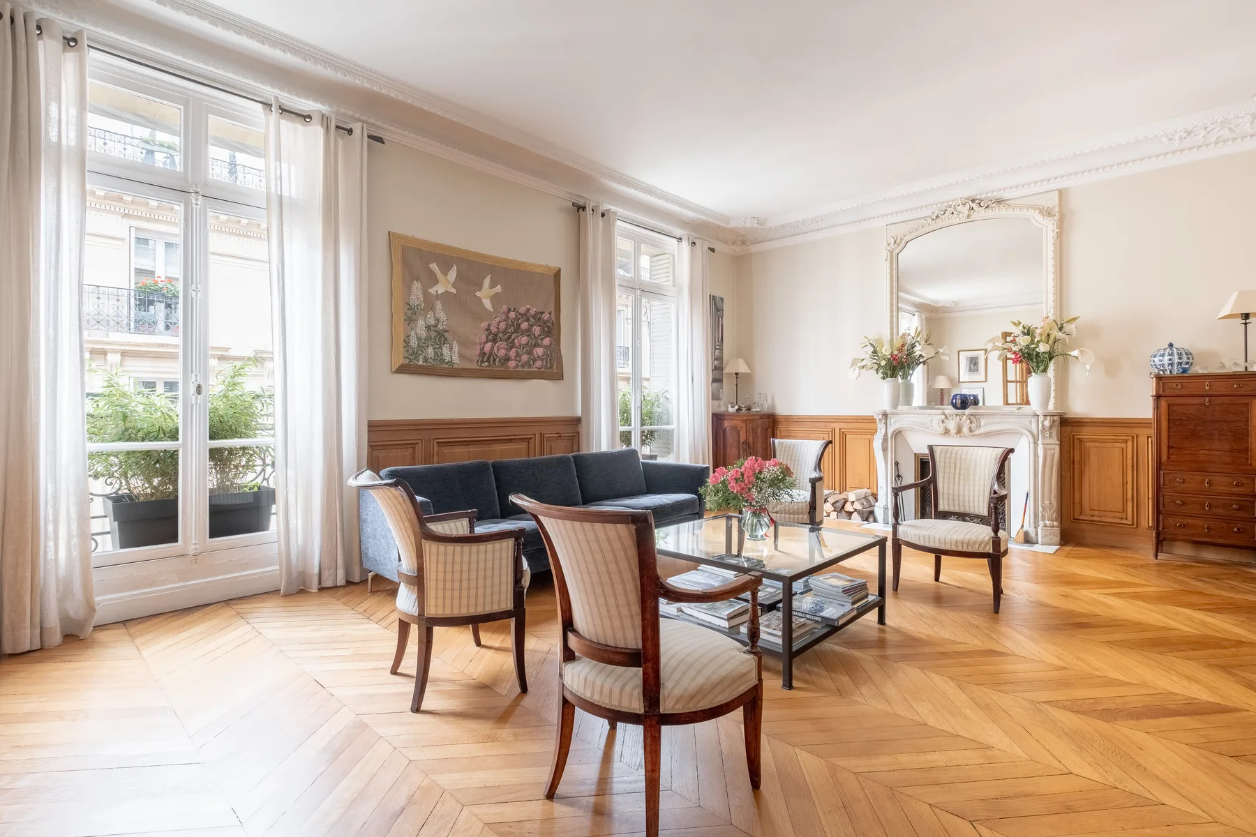 A bright living room with seating arranged around a glass coffee table.