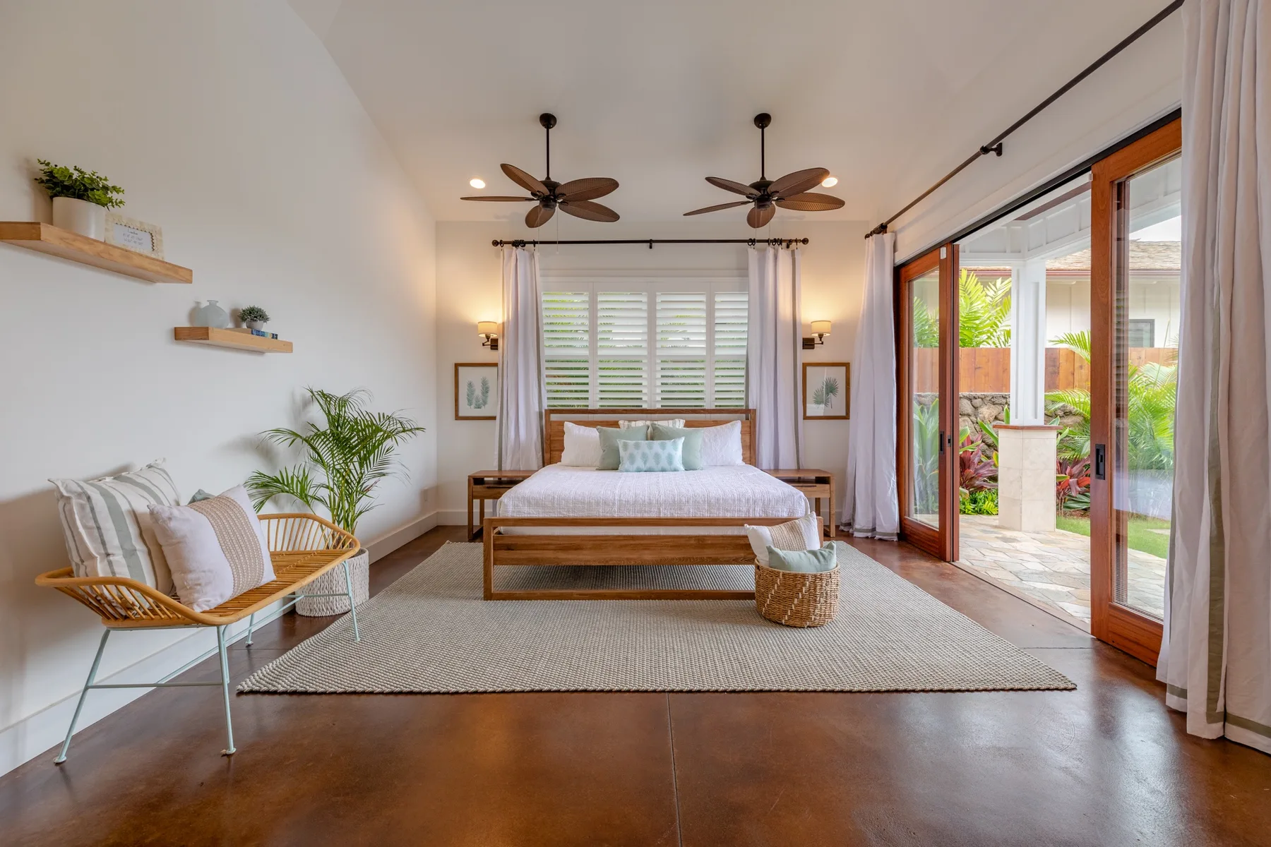 A bright bedroom with a bed, seating, and glass doors opening to a patio.