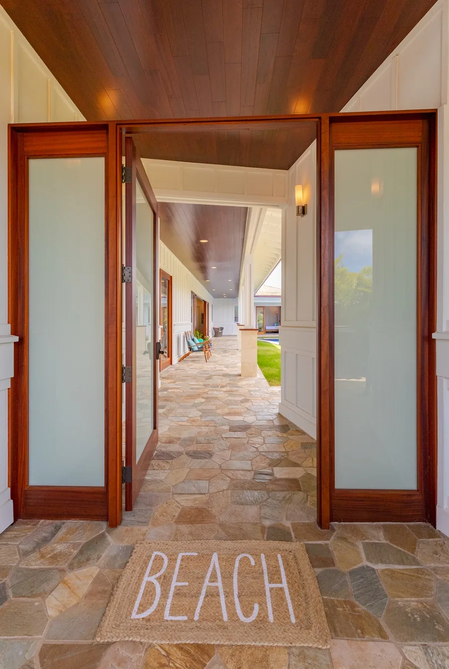 An open entryway leads to a covered passage with stone flooring.