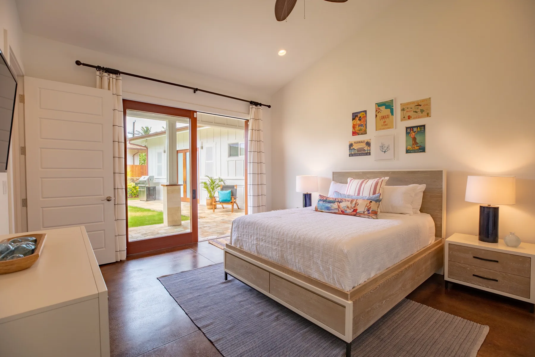 A bedroom with a bed beside glass doors opening onto a patio.