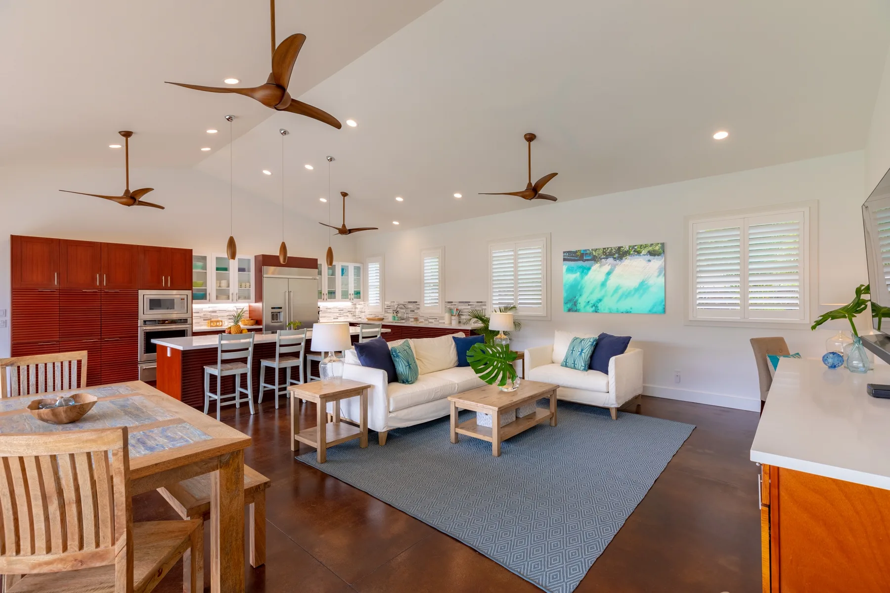 An open living and dining area with a seating area, dining table, and kitchen.