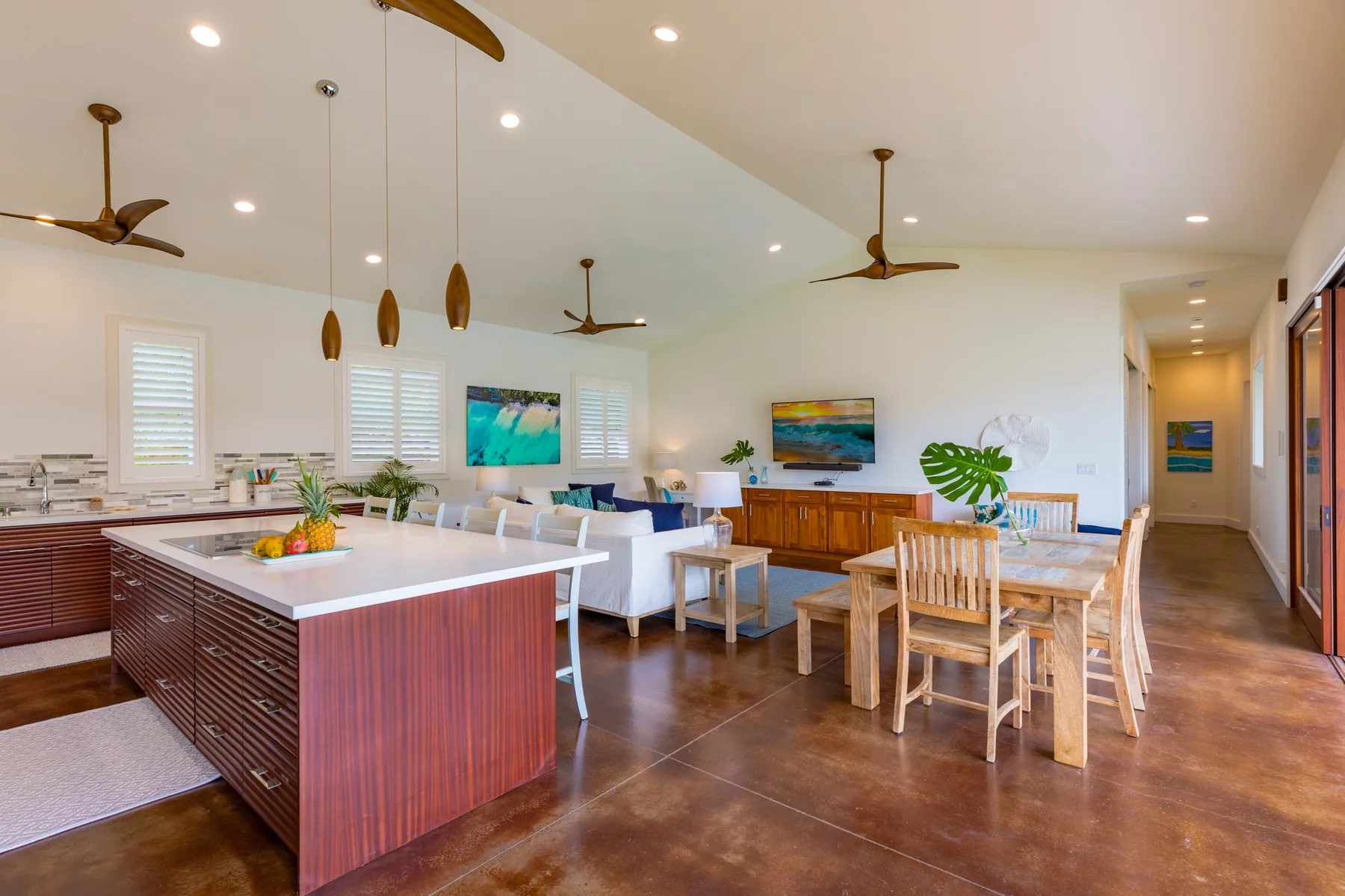 An open kitchen and dining area with a large island and wooden dining table.