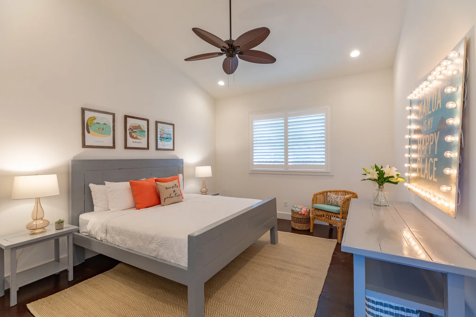 A bright bedroom with a bed, window, and a small seating area.