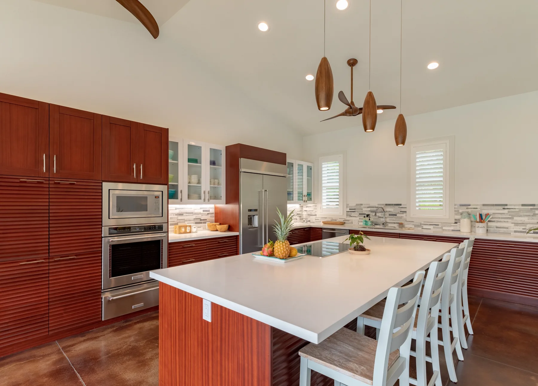 Una cocina luminosa cuenta con una isla grande y electrodomésticos de acero inoxidable.