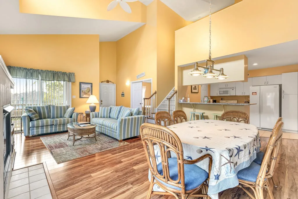 A bright open-plan living and dining area has a table beside the seating.