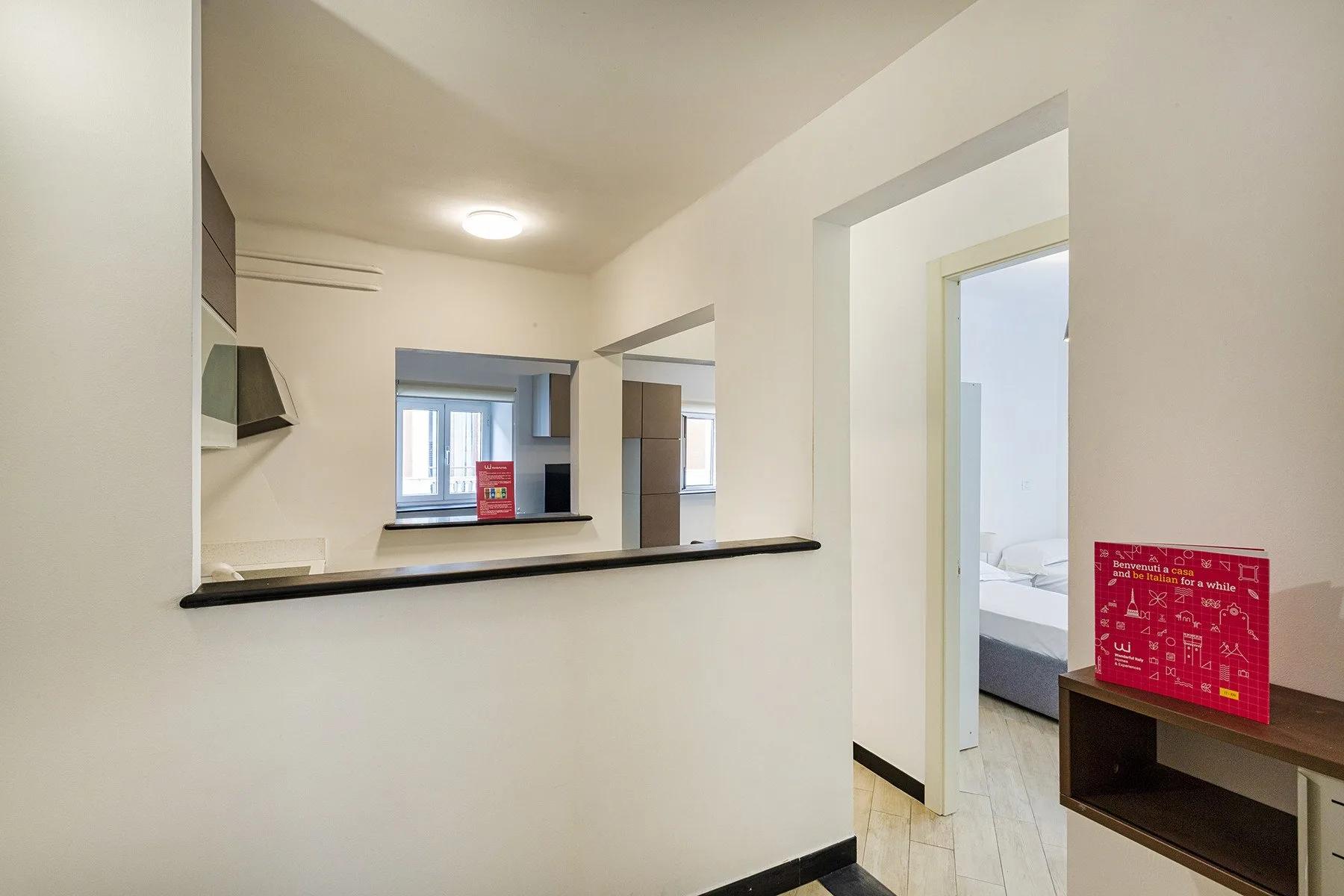 A bright interior passage opens onto a bedroom, with a counter in the foreground.