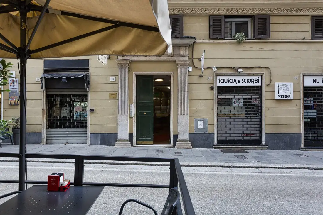 A street-facing storefront with a dark green entrance beneath an outdoor awning.