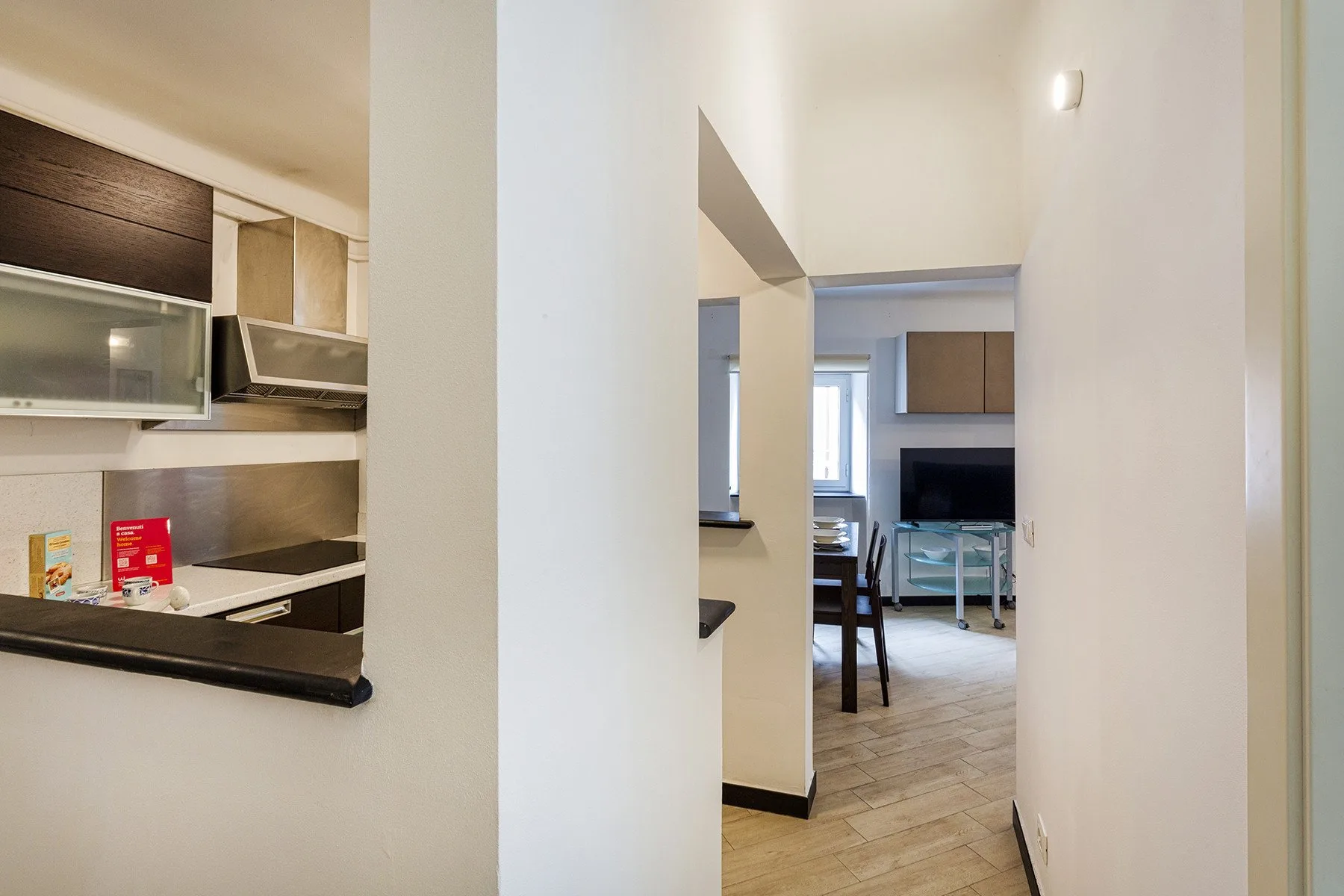 A hallway opens onto a dining area with a table and chairs.
