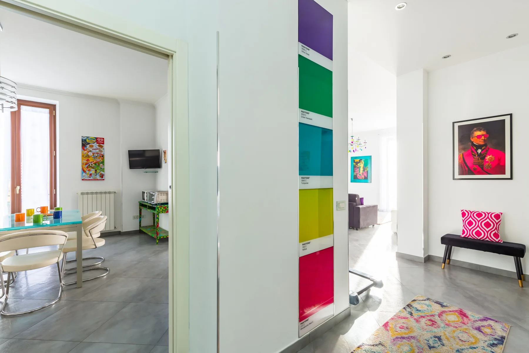 A bright interior hallway opens onto a dining area and a colorful lounge.