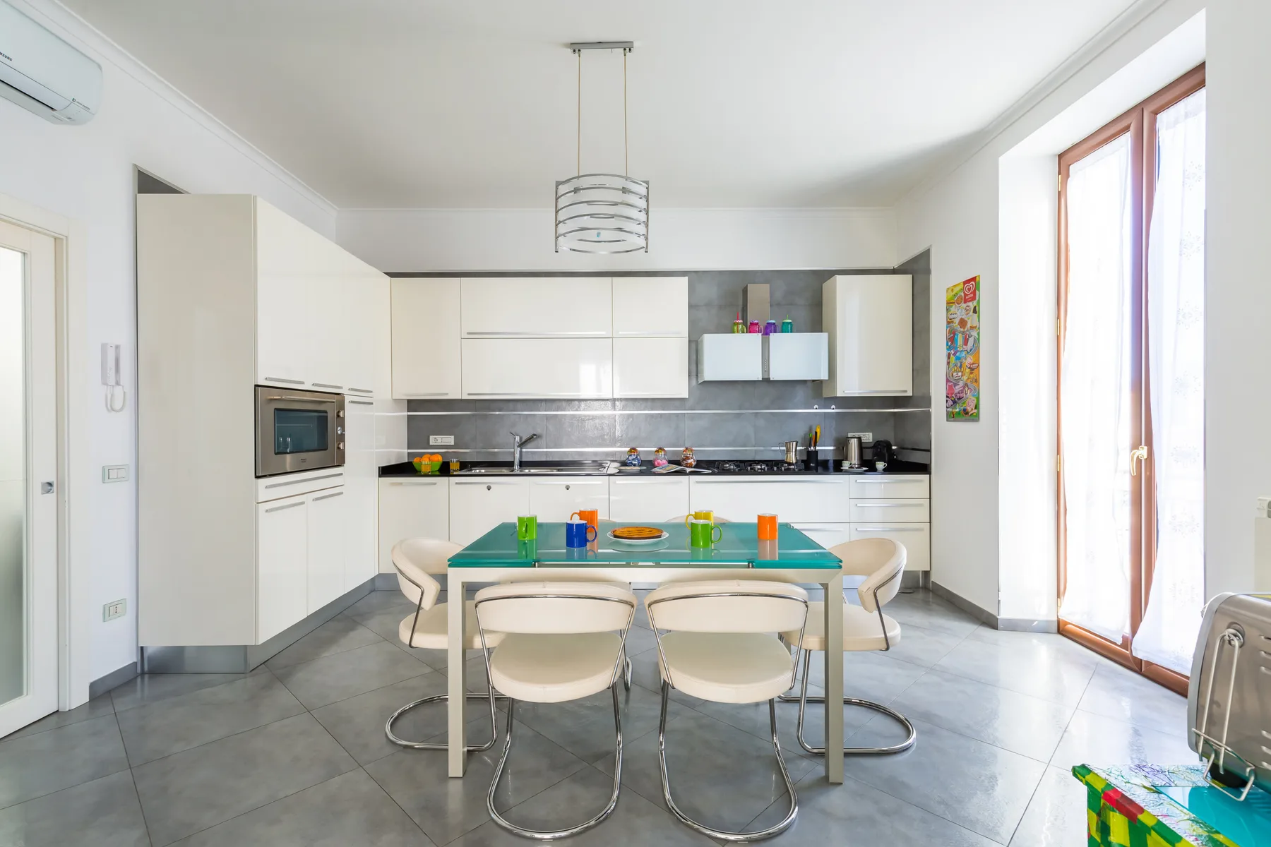 A bright kitchen with white cabinets and a dining table.