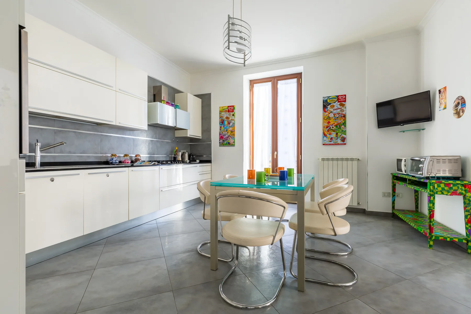 A bright kitchen and dining area with white cabinetry and a table by the window.