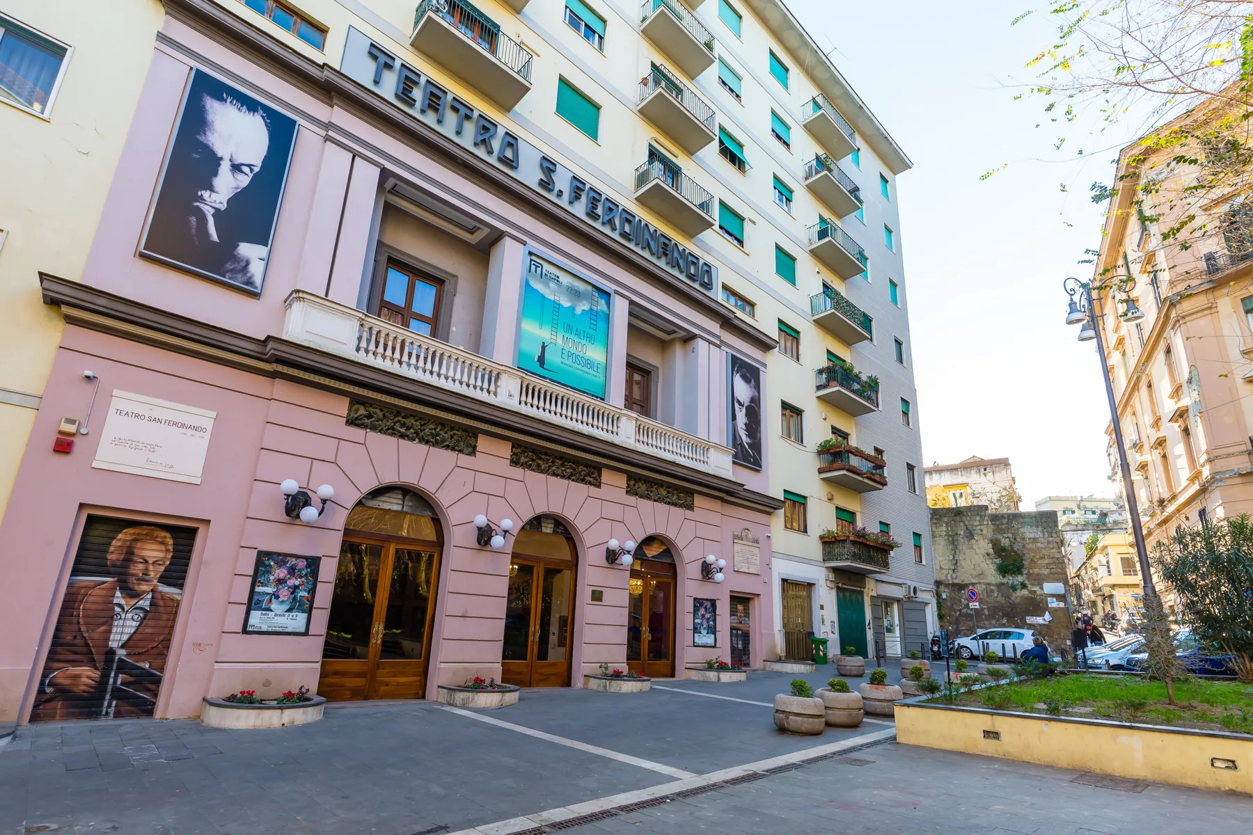 A city street scene with a theater facade and a paved plaza.