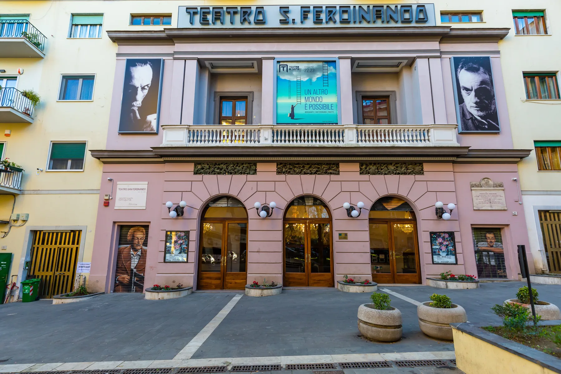 A theater facade with arched entrance doors and large posters above the entrance.