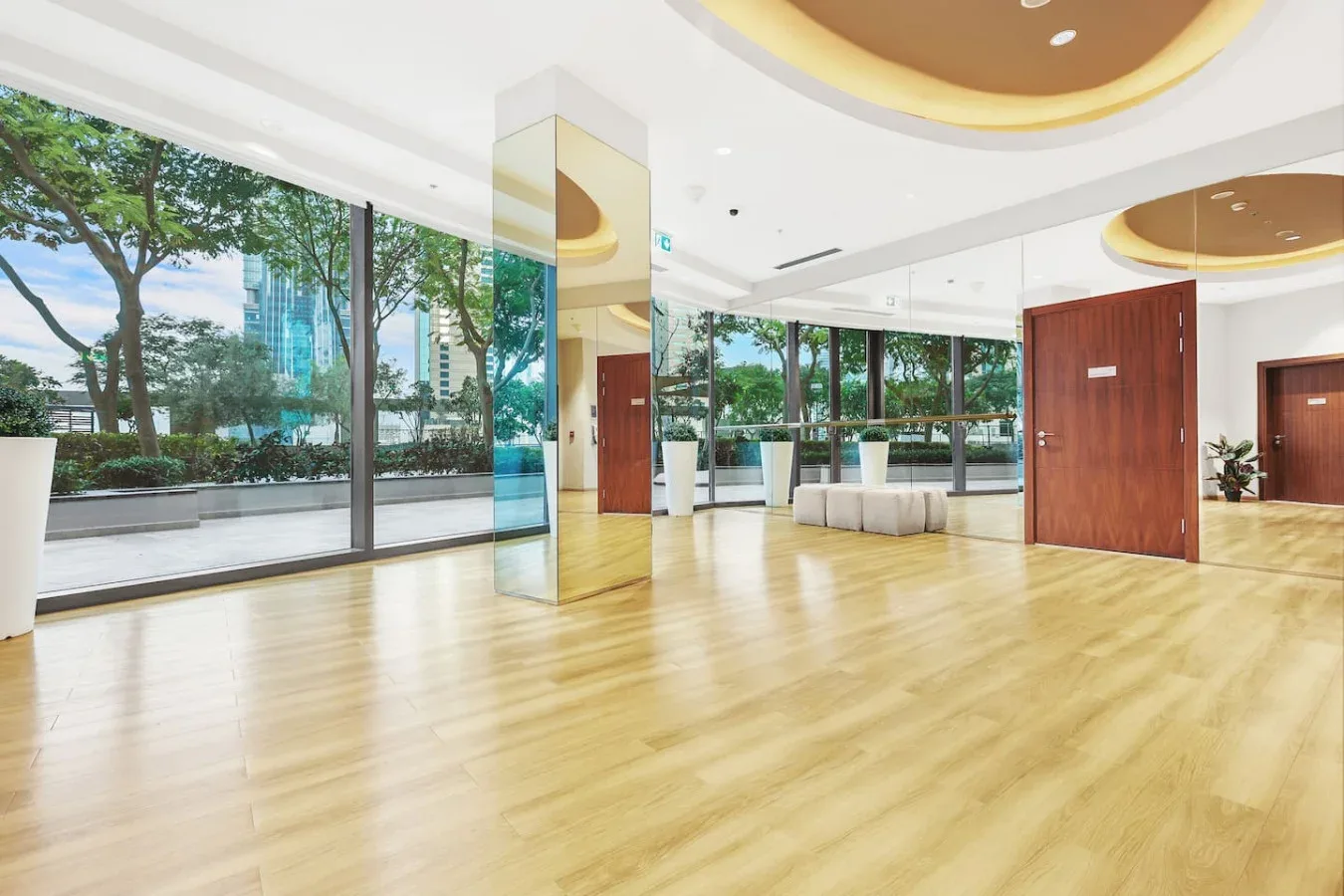 A bright lobby with floor-to-ceiling windows and a spacious wood-look floor.