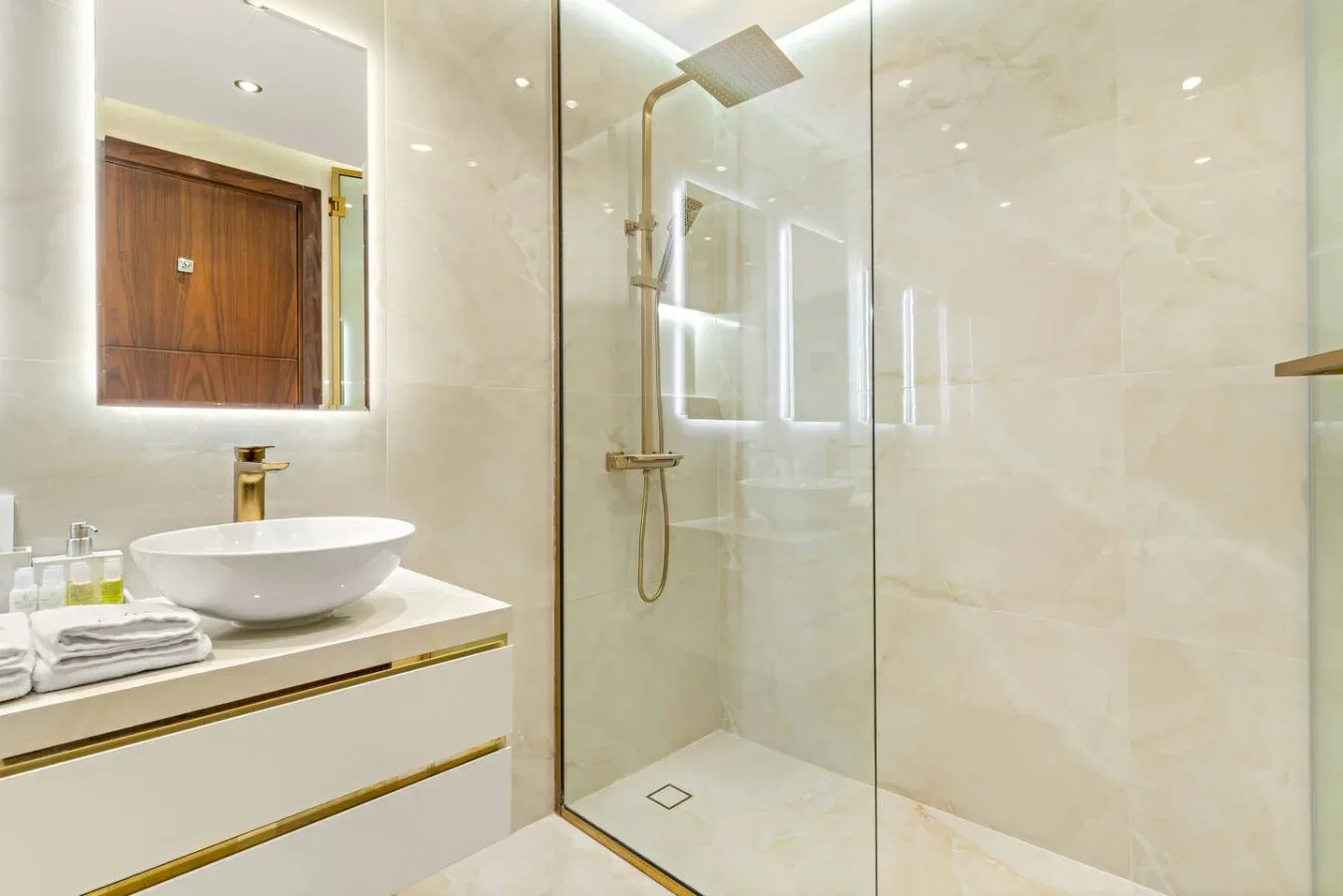 A bright bathroom with a vanity and a glass-enclosed shower.