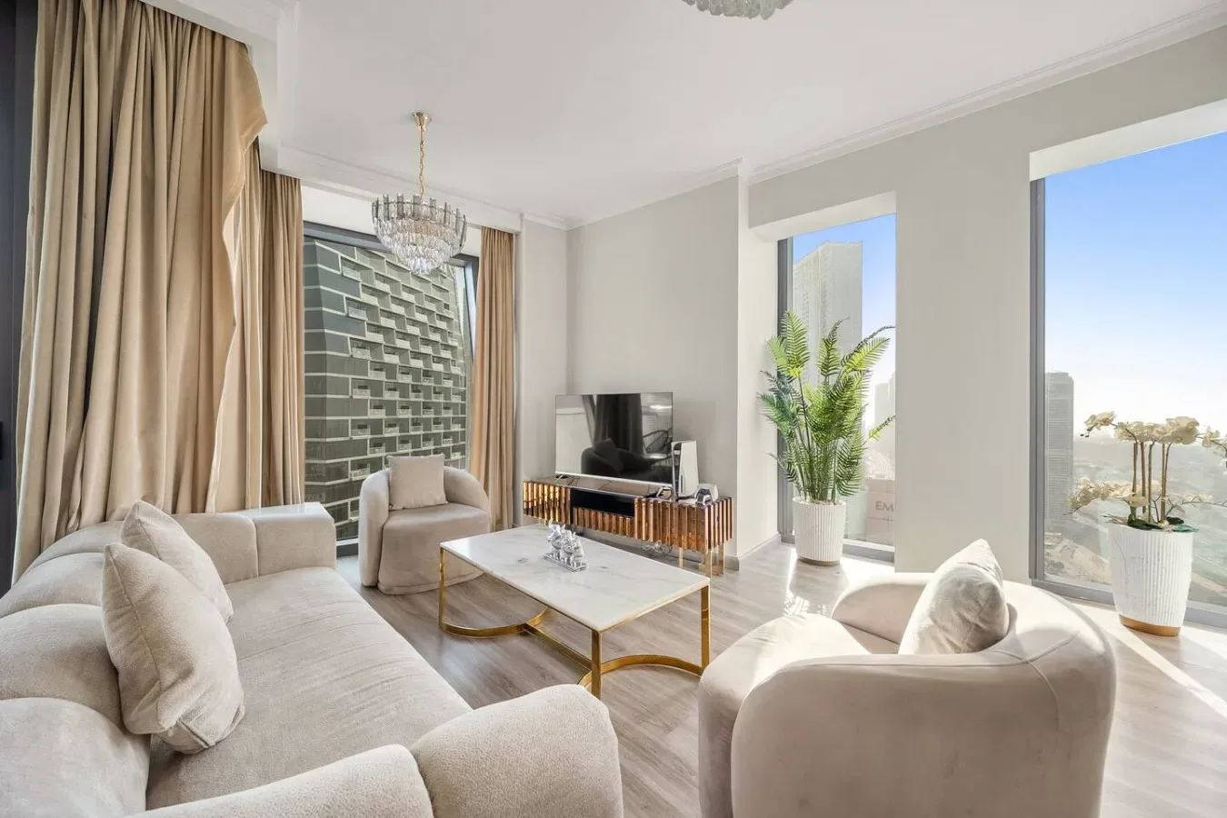 A bright living room with seating, a coffee table, and large windows.