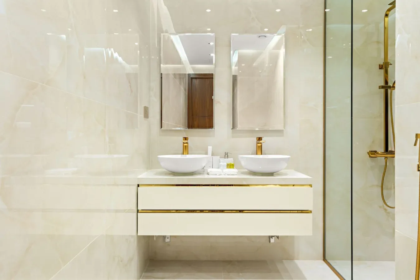 A bright bathroom with a double sink vanity and a glass shower.