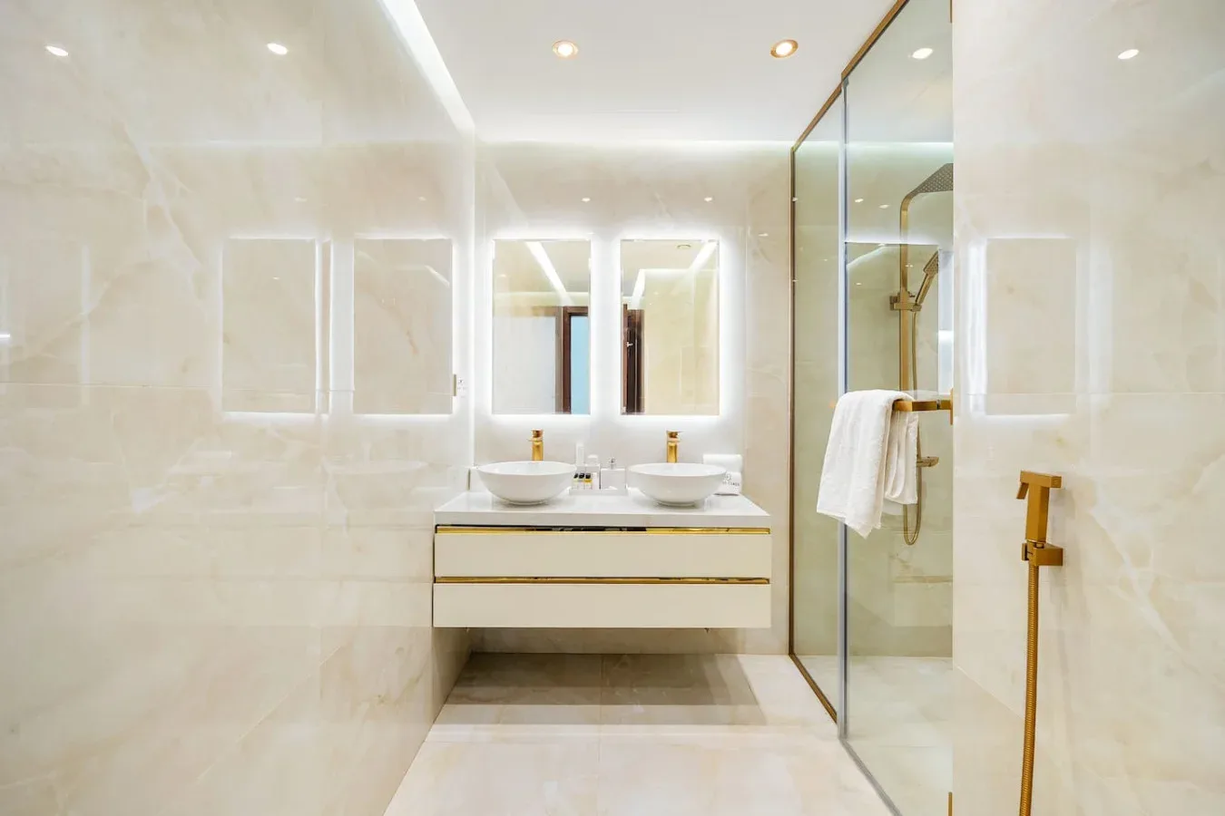A bright bathroom features a double sink vanity and glass shower.