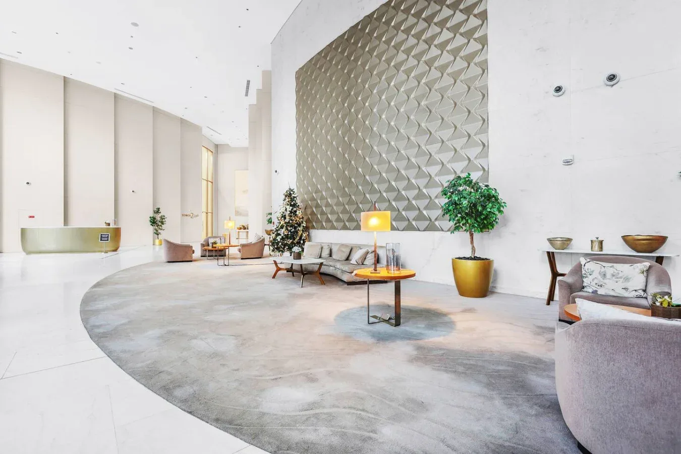 A bright lobby with a curved seating area and a geometric wall feature.