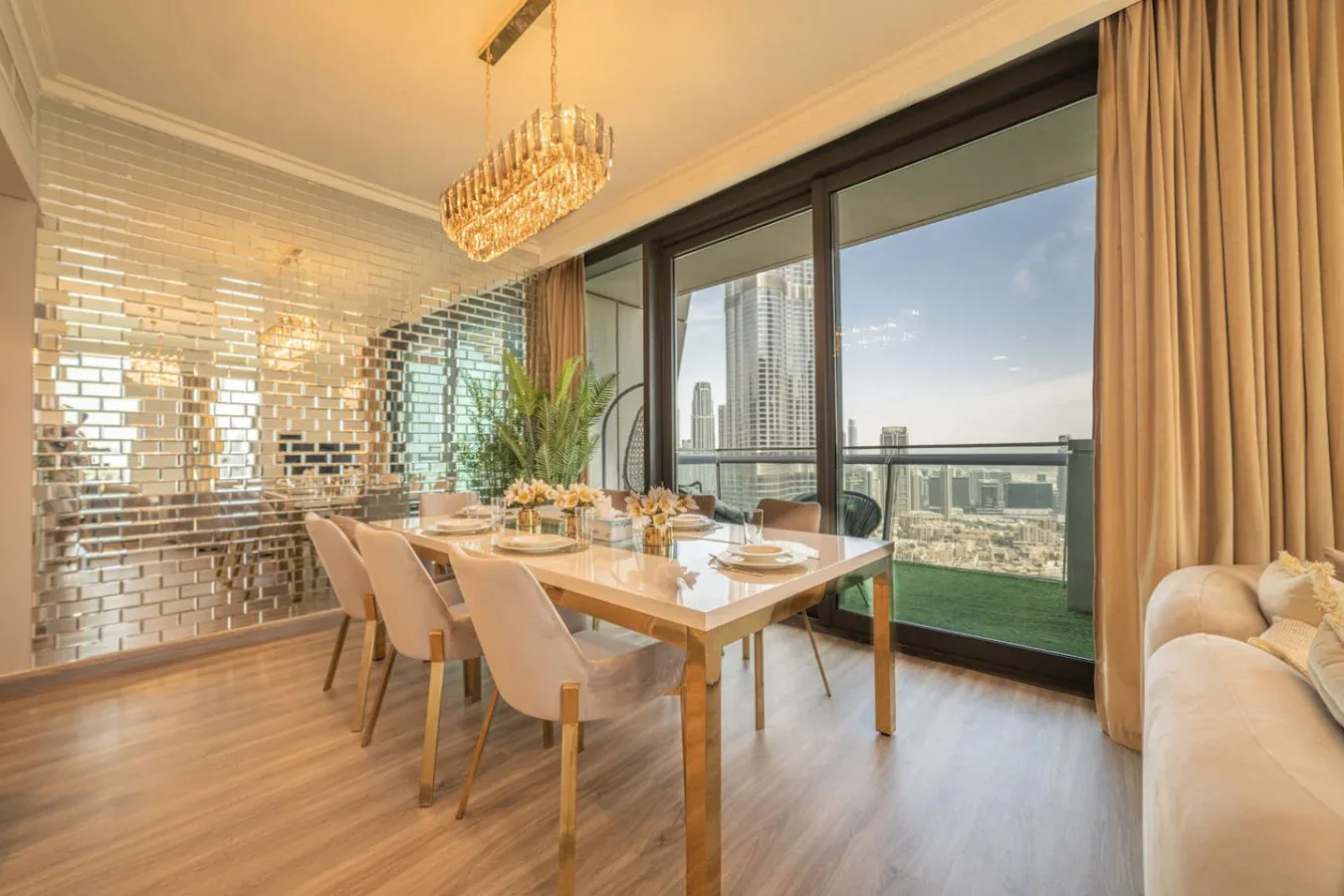 A dining area with a set table beside large windows overlooking the city.
